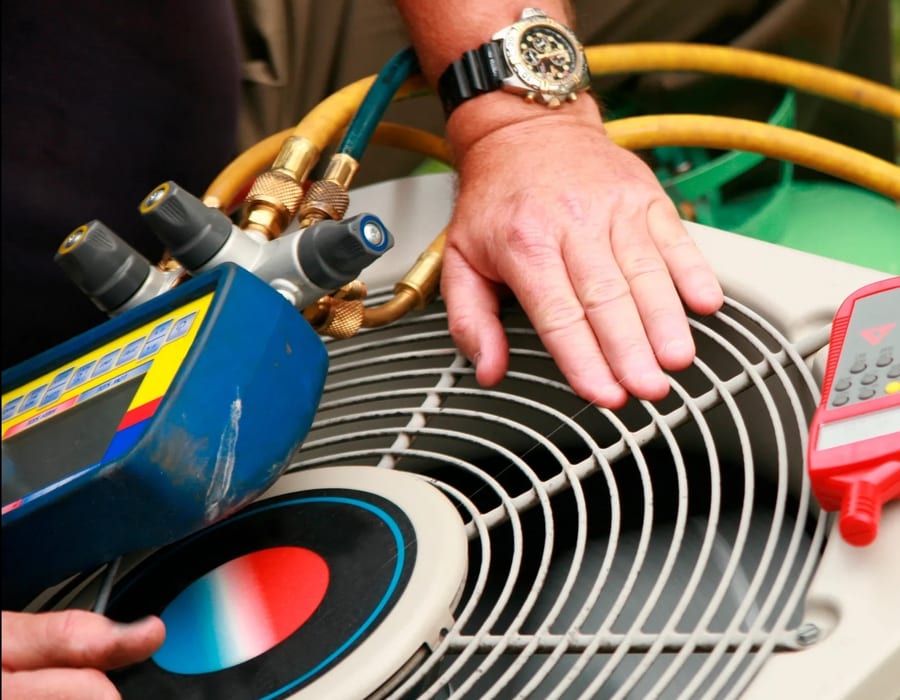 Technician repairing an outdoor residential air conditioning unit